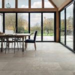 Open plan kitchen diner with vaulted ceilings and large glass windows looking out into the garden.